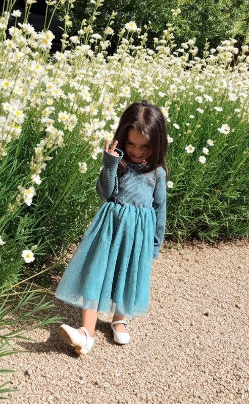 Young girl in Ella dress standing in a field of white flowers