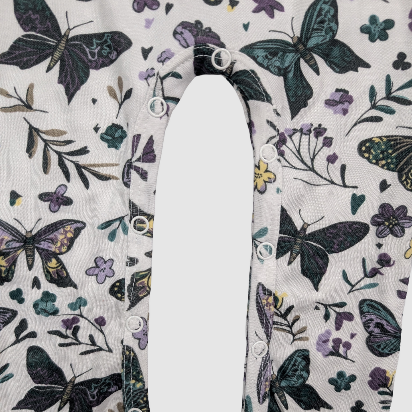 Close-up of snaps with butterfly and floral pattern on a white background