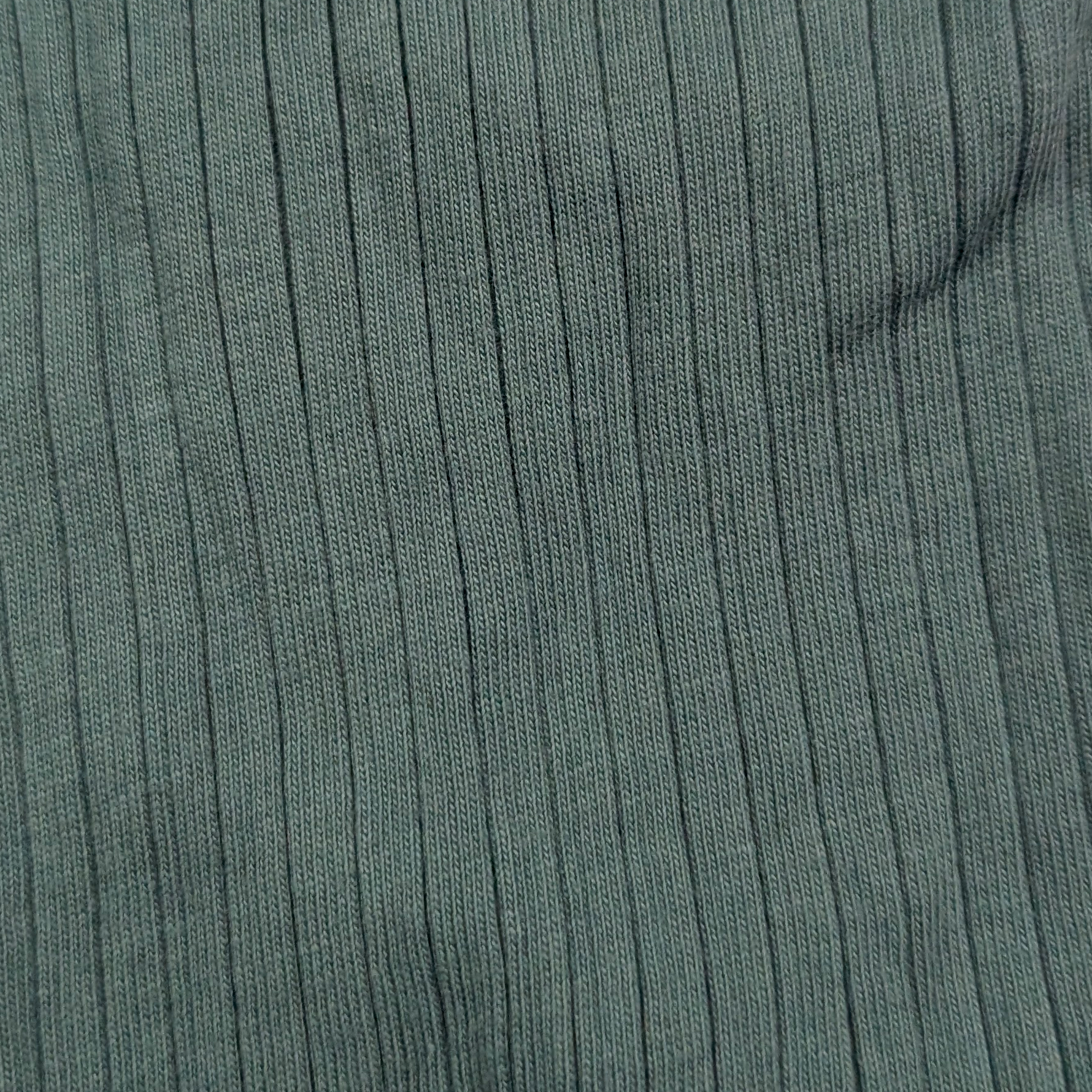 Close-up of green ribbed fabric texture organic cotton